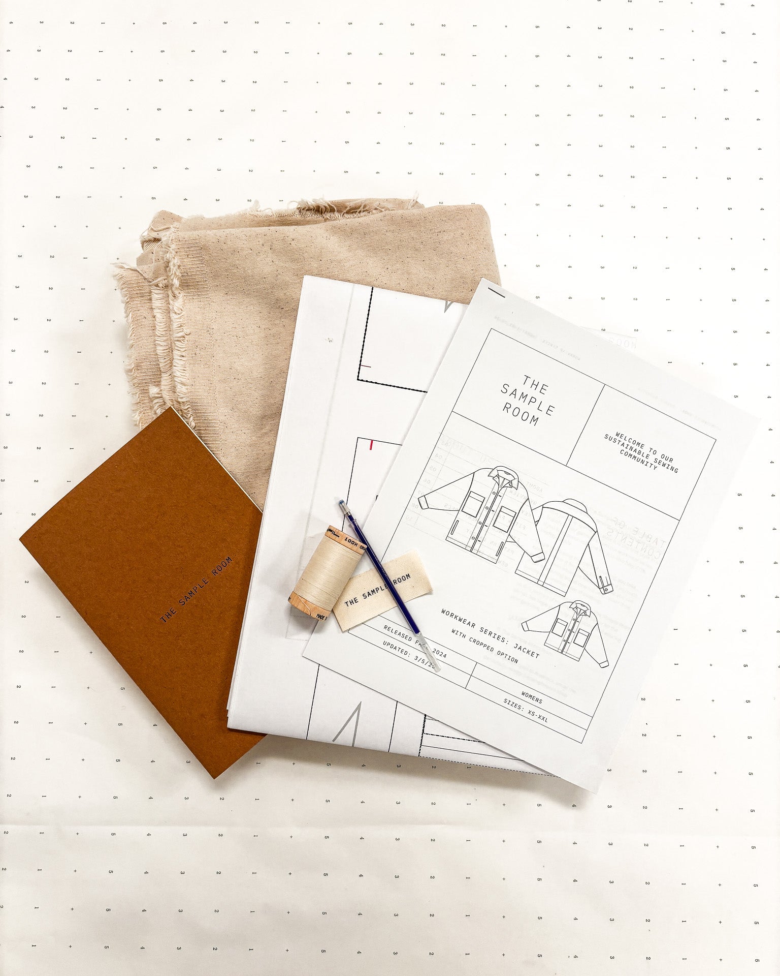 Pattern paper with sewing tools on a white surface